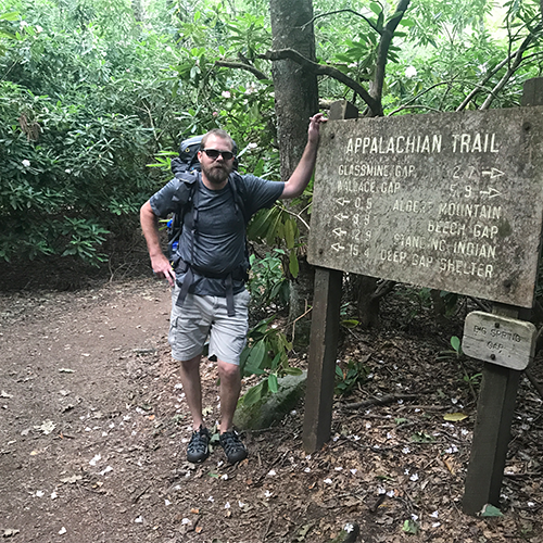 Obadiah Brooks standing next to a sign for the Appalachian Trail.